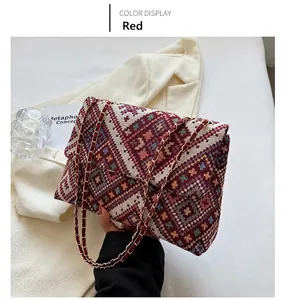 Detail view of woven geometric pattern shoulder bag with a gold metal chain strap