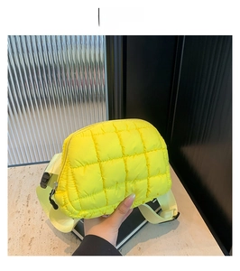 Gros plan d'un sac bandoulière en nylon matelassé jaune fluo avec fermeture éclair