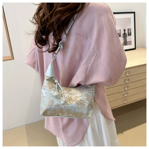 Close-up of light blue silk bucket bag with gold oriental landscape embroidery