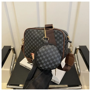 Detail of retro checkered two-in-one crossbody bag with round pouch on a leather chair