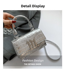 Detail of silver crocodile pattern mini bag with metallic M buckle and top handle