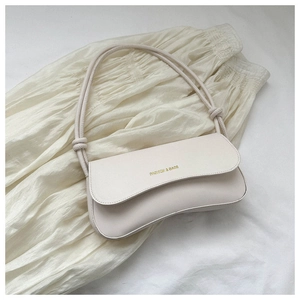 Close-up of cream beige PU leather shoulder bag with gold embossed FASHION & BAGS logo