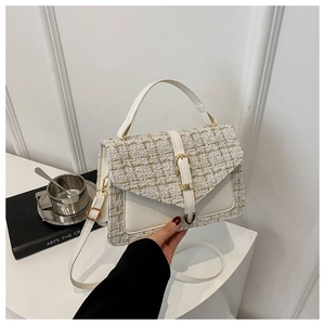 Gros plan du sac à main en tweed blanc avec boucle dorée et poignée élégante