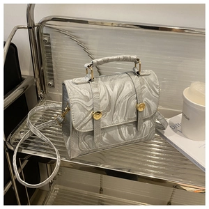 Détail d'un sac à main argenté texture marbre avec boucles dorées et bandoulière