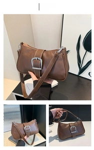 Dettagli di una borsa baguette retrò marrone con fibbia in argento e trama in ecopelle