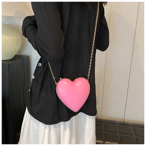 Pink heart-shaped hard shell crossbody bag with gold metal trim and chain strap