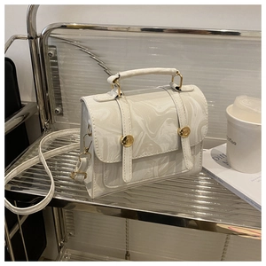 Vue détaillée du sac à main à motif marbre avec boucles dorées et poignée
