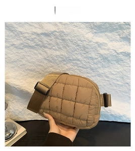 Détail d'un sac bandoulière matelassé marron avec bandoulière réglable et zip de fermeture