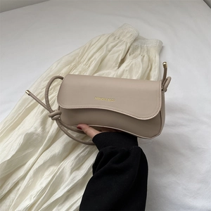 Minimalist beige matte leather shoulder bag with knotted strap and gold metal details