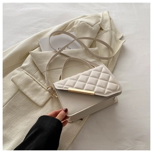 Detail of off-white quilted handbag featuring a sleek gold metal bar twist-lock closure