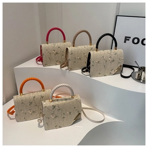 Close-up of assorted woven bags with floral embroidery and leather braided handles