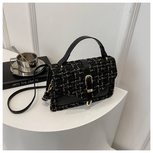 Détail du sac bandoulière en tweed et cuir avec boucle dorée sur présentoir blanc