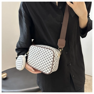 Detail of crossbody camera bag set featuring vintage logo pattern and wide shoulder strap