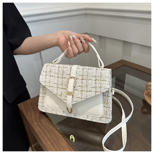 Gros plan d'un sac à main en tweed blanc avec finitions en cuir beige et boucle en métal