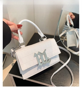 Close-up of white crocodile pattern handbag with silver metal B logo and chain detail