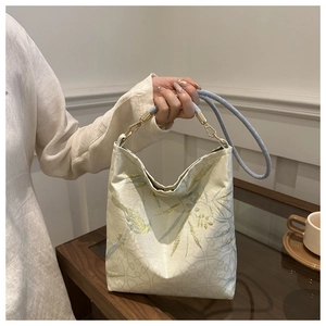 Detailed embroidery and blue cylindrical handle on the minimalist Chinese style tote bag