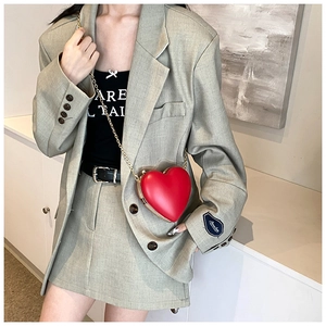 Red heart-shaped hard shell crossbody bag with a delicate gold metal chain strap