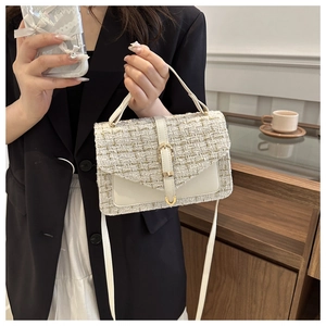 Détail du sac à bandoulière en tweed crème avec poche en cuir et boucle dorée