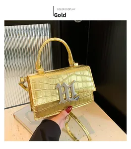 Detailed view of gold crocodile embossed leather handbag with silver B metal buckle