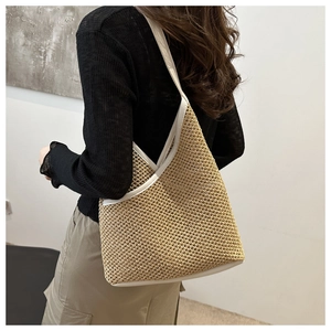 Detail of hand-woven straw bucket bag with white leather straps and a minimalist V-shaped rim