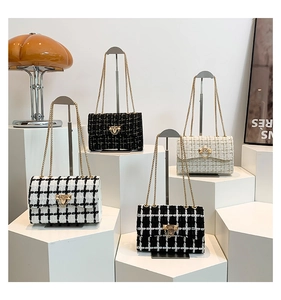 Detail of tweed crossbody bags featuring gold metal locks and elegant chain straps