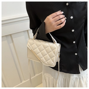 Detail of white quilted crossbody bag with gold metal hardware and adjustable strap