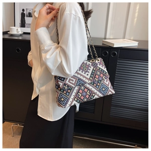 Detail of bohemian colorful woven shoulder bag with geometric patterns and gold chain strap