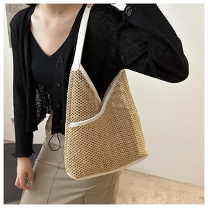 Detail of hand-woven straw bucket bag with white faux leather trim and shoulder strap