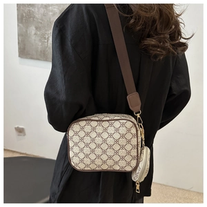 Detail of printed crossbody bag with wide strap and round coin purse on black blazer