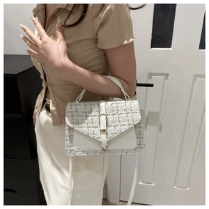 Détail du sac à main en tweed blanc avec tissage doré et fermeture à rabat en cuir