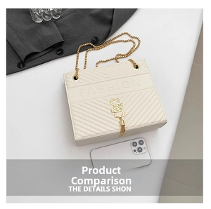 Detail of cream quilted crossbody bag with gold S-charm and chain strap for size reference