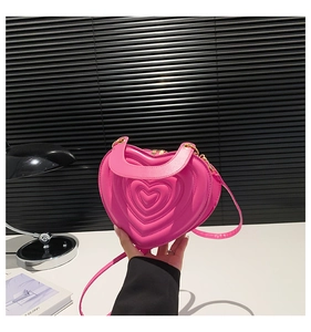 Detail der rosaroten herzförmigen Handtasche mit konzentrischer Herzsteppung und Reißverschluss