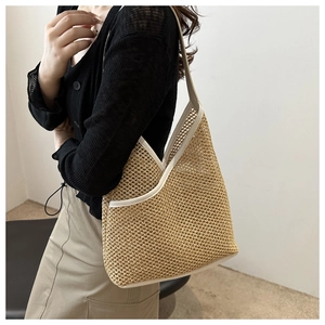 Detail of hand-woven straw bucket bag with white leather trim and hollow mesh texture