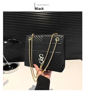 Close-up of black quilted shoulder bag with V-shaped texture and gold chain strap
