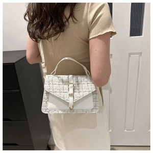 Détail du sac à main en tweed blanc avec rabat enveloppe et boucle dorée en situation