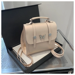 Close-up of cream PU leather handbag with silver butterfly clasp and structured design