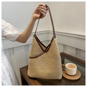 Detail of handwoven straw underarm bag featuring brown leather trim and retro texture