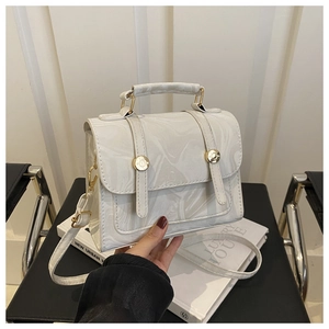 Détail d'un sac à main à motif marbre blanc avec boucles métalliques dorées
