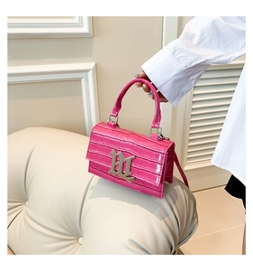 Detail shot of hot pink croc-effect mini bag with silver metal gothic letter buckle