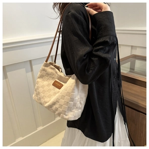 Detail of cream woven tote bag showing 3D texture and stylish brown shoulder straps