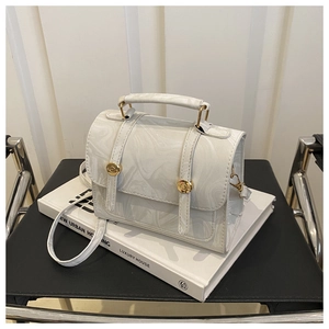 Détail du sac à main à motif marbré avec boucles dorées et poignée en cuir élégante