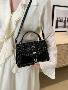 Sac bandoulière en tweed noir chic avec boucle dorée porté par un mannequin en blanc