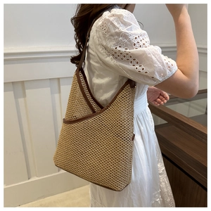 Detail of hand-woven bucket bag featuring brown leather trim and mesh straw texture