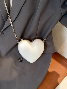 Elegant white heart-shaped crossbody bag with pearl finish and gold chain strap