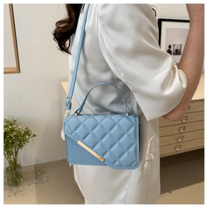 Quilted light blue crossbody bag with gold accents and elegant top handle for women
