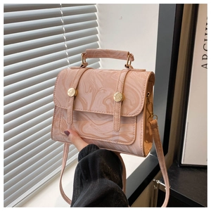 Détail d'un sac à main rose à motif marbré avec finitions dorées et aspect brillant