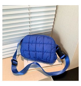 Détail du sac banane matelassé bleu en nylon avec texture à carreaux et sangle
