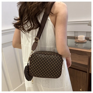 Detail of crossbody bag with vintage brown pattern and mini round coin purse charm