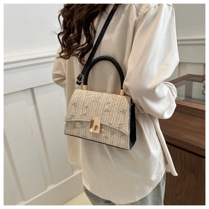Detail of straw woven bag with floral embroidery and gold twist lock closure