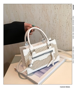 Détail du sac à main blanc en cuir et mesh avec fermeture éclair et gland décoratif